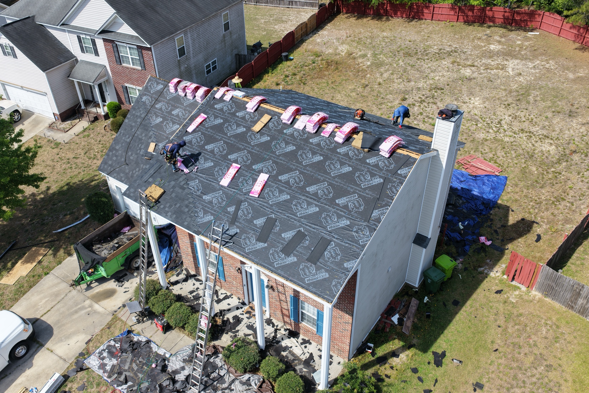 Exterior Genie crew installing RhinoRoof underlayment on a brick home